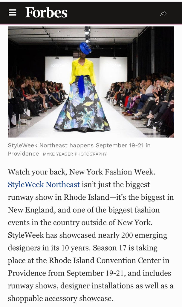 Model walking the runway in a Lalla Bee custom design at StyleWeek Northeast, featuring a bold floral skirt and yellow blouse, showcasing luxury dresses by independent designer Melina Cortes.