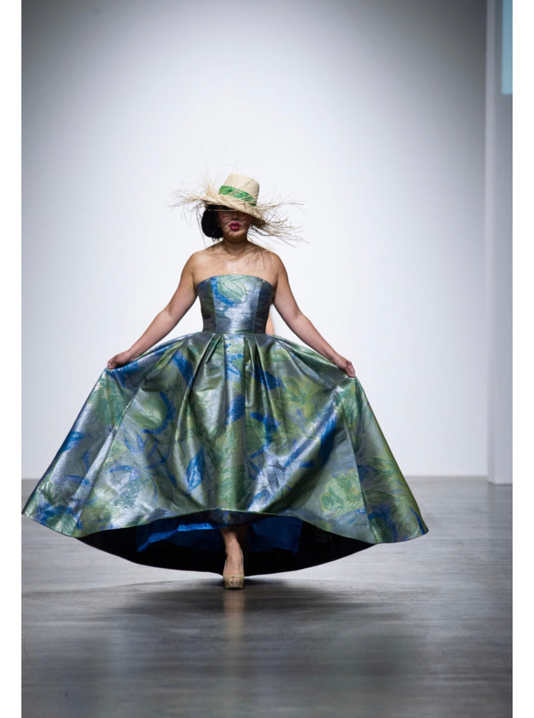 Model walking down the runway with a custom made lalla bee gown