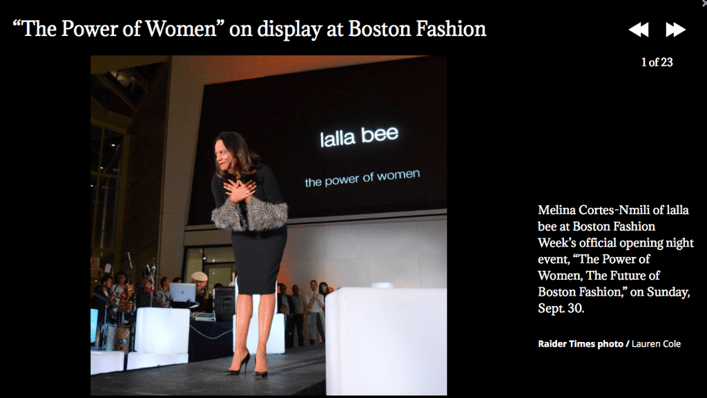 Melina Cortes-Nmili bows on stage at Boston Fashion Week opening night event The Power of Women, with Lalla Bee logo displayed behind her.