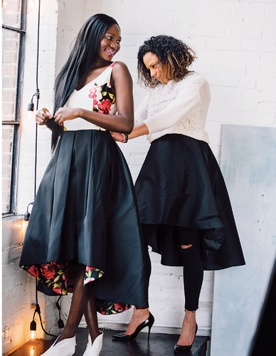 Melina Cortes-Nmili fitting a model in a black high-low floral dress from her Lalla Bee collection, showcasing custom design, luxury dresses, and independent sustainable fashion in Boston.