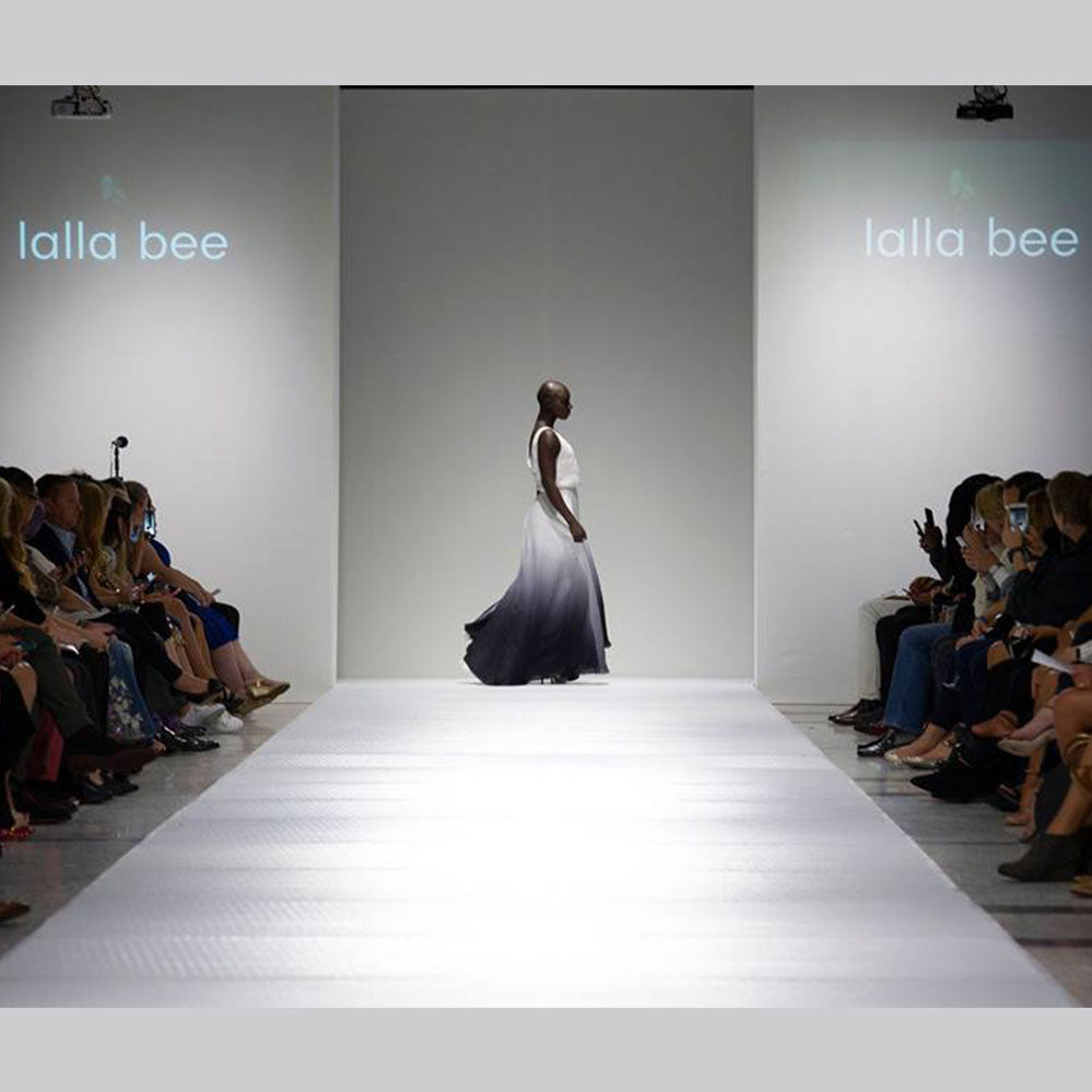 Model walking the runway in a flowing black and white gradient gown during Lalla Bee’s showcase at StyleWeek Northeast.
