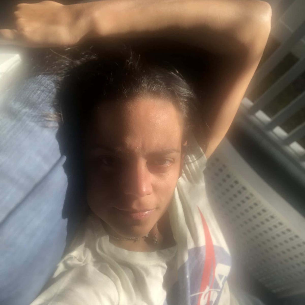 Close-up selfie in natural light with relaxed pose and soft shadows.