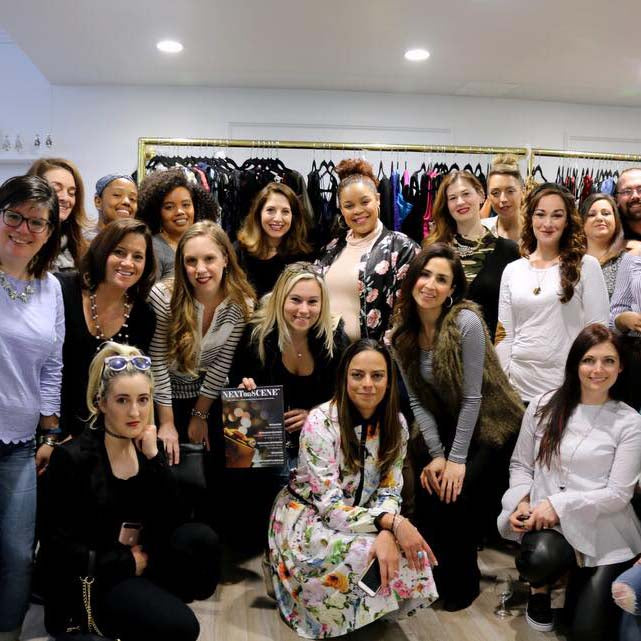 Group of women gathered at Lalla Bee Fashion Night Out event inside a boutique surrounded by clothing racks.