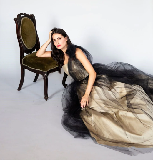 woman in luxury lalla bee dress, leaning in a chair