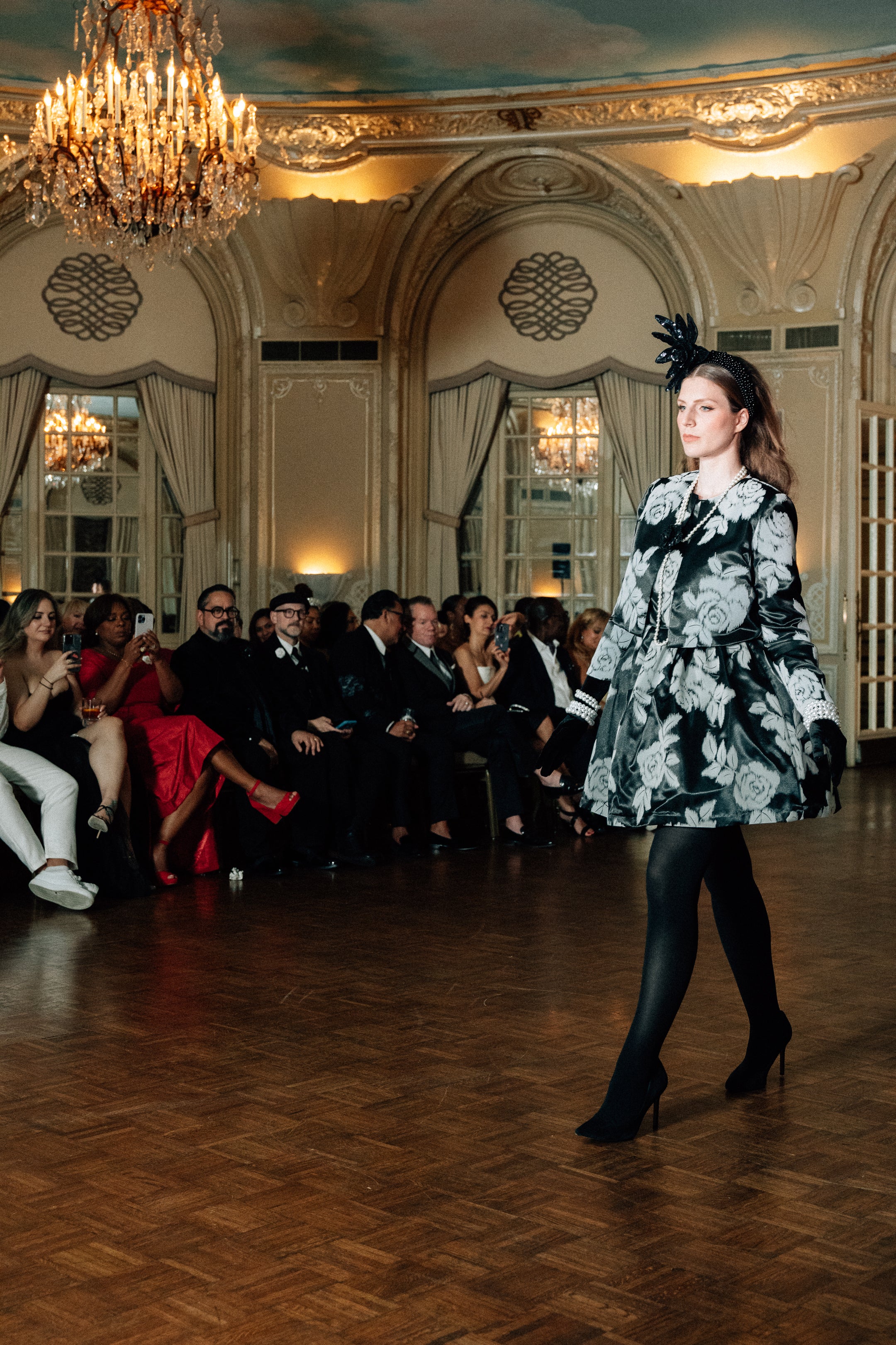 Model wearing the Lalla Bee Velvet Rose with Jacket, a black floral velvet dress paired with a matching jacket, accessorized with a statement headpiece, perfect for luxury events and galas.