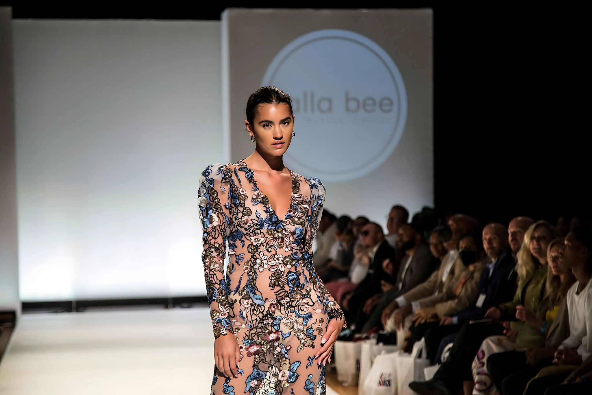 Model walking at a fashion show in the Olga Dress by Lalla Bee, highlighting modern elegance with bold embroidered florals.